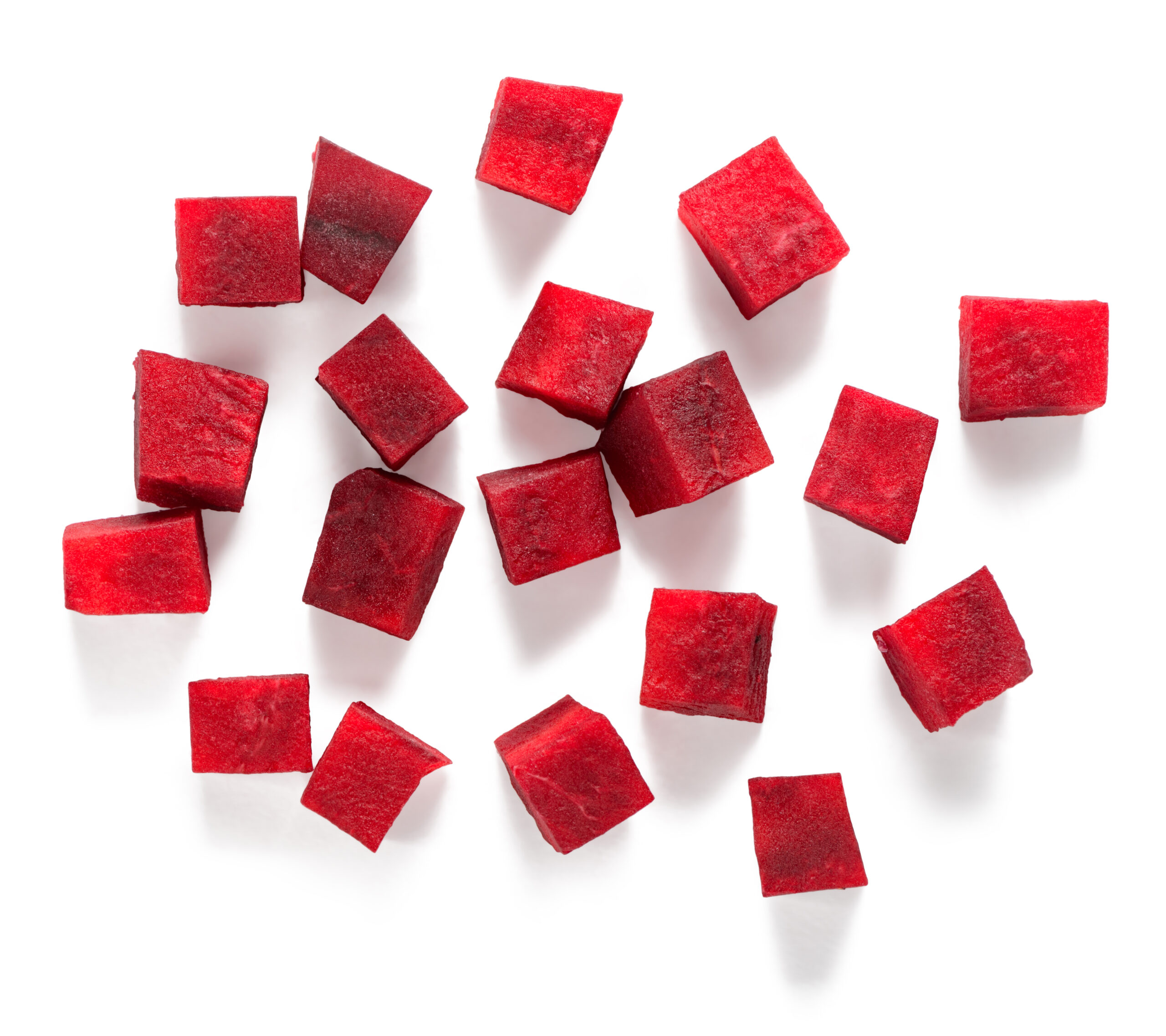 Beetroot diced in medium cubes on white background. Prepared vegetable for adding to food.